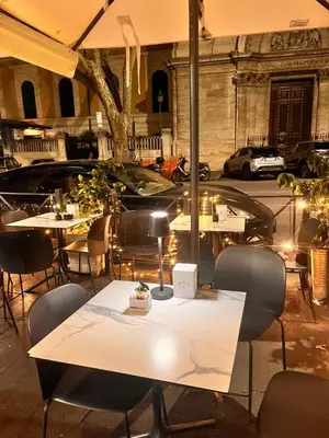 a restaurant with tables and chairs and a car at Monia Coliseum Apartment in Rome