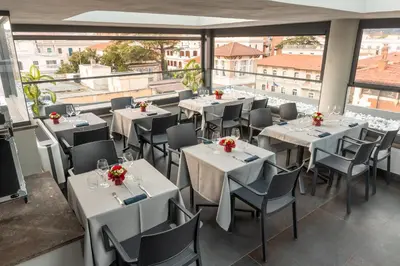 a restaurant with white tables and chairs and windows at Twentyone Hotel in Rome