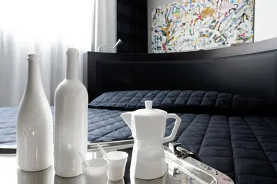 a table with bottles and glasses on a bed at Twentyone Hotel in Rome