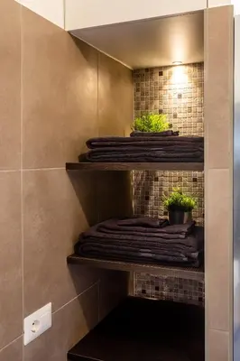 a bathroom with shelves with towels and potted plants at Domus Maya Colosseum in Rome