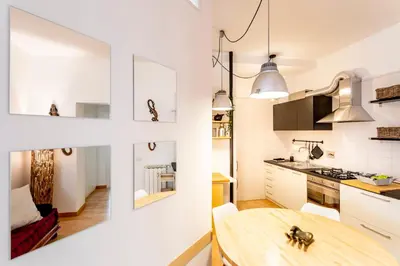 a kitchen and dining room with a wooden table at Domus Maya Colosseum in Rome