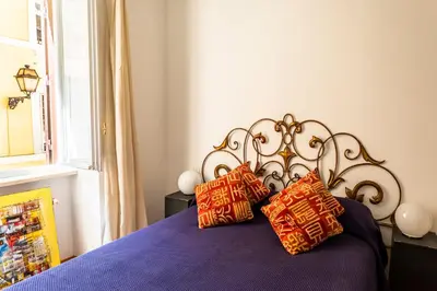 a bedroom with a bed with purple sheets and pillows at Domus Maya Colosseum in Rome