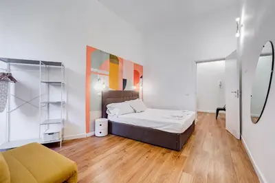 a small bedroom with a bed and a mirror at BMGA l Central Holiday House 2Bdr near Vatican in Rome