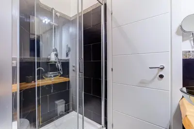 a shower with a glass door in a bathroom at BMGA l Central Holiday House 2Bdr near Vatican in Rome