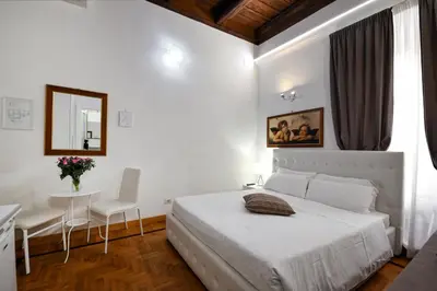 a white bedroom with a bed and a table and chairs at Roman Nights in Rome
