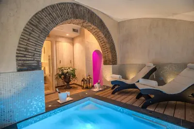 a pool in a room with two chairs and a swimming pool at Boutique Relais Barozzi & SPA in Rome