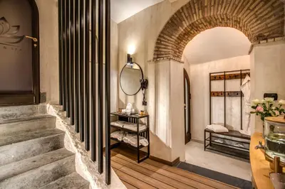 a hallway with an archway and stairs with a mirror at Boutique Relais Barozzi & SPA in Rome