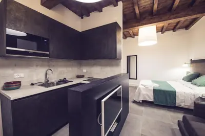 a kitchen with a sink and a bed in a room at Dolcevita Apartments in Rome