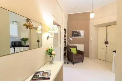 a living room with a mirror and a chair at Pamphili Park Romantic Retreat in Rome