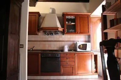 a kitchen with wooden cabinets and a stove top oven at Portico d'Ottavia, the ancient Rome in Rome