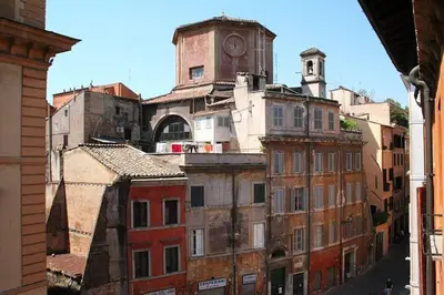 a group of old buildings with a clock tower at Portico d'Ottavia, the ancient Rome in Rome
