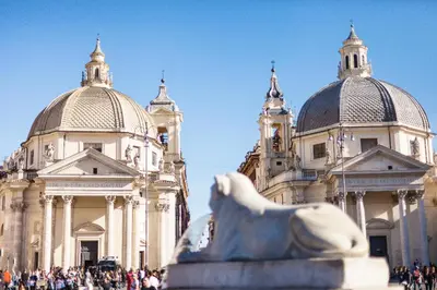 a building with two domes and a statue in front of it at The Brunetti - Luxury serviced apartment in Rome