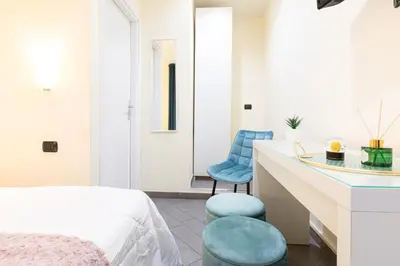 a bedroom with a bed and two blue chairs at Cesar Vatican Rooms in Rome