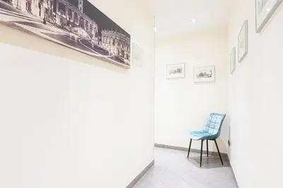 a room with a blue chair and pictures on the wall at Cesar Vatican Rooms in Rome