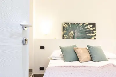 a bedroom with a bed and a painting on the wall at Cesar Vatican Rooms in Rome