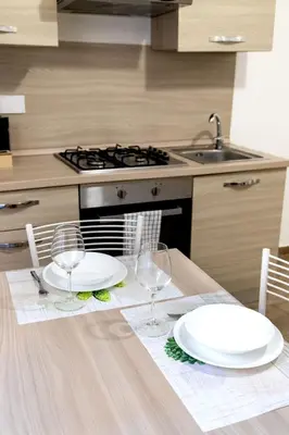 a kitchen with a table with plates and wine glasses at Sannio Apartment - near Metro San Giovanni by RHR in Rome