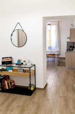 a living room with a mirror hanging on the wall at Sannio Apartment - near Metro San Giovanni by RHR in Rome