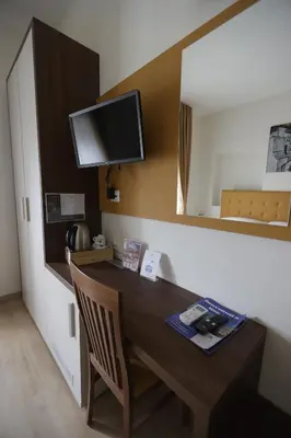 a dining room with a table and a tv on a wall at B&B A Picture of Rome in Rome