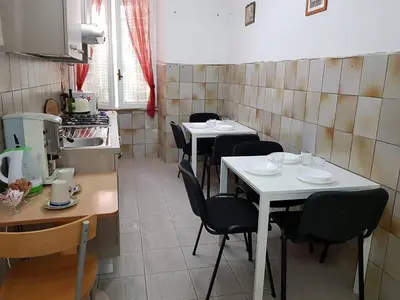 a kitchen with four tables and chairs in a room at APPARTAMENTO SIMONE DUE in Rome
