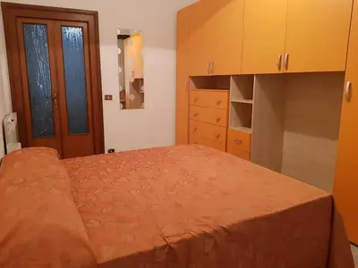 a bedroom with a bed with an orange bedspread at APPARTAMENTO SIMONE DUE in Rome