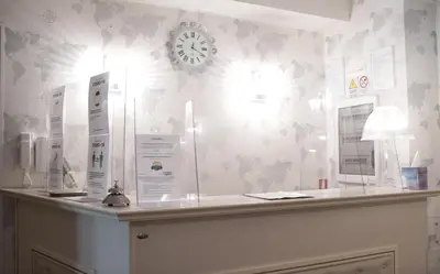 a room with a counter with a clock on the wall at Locanda Navona in Rome
