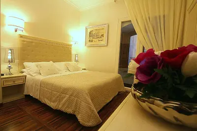 a bedroom with a bed and a vase of flowers at Locanda Navona in Rome