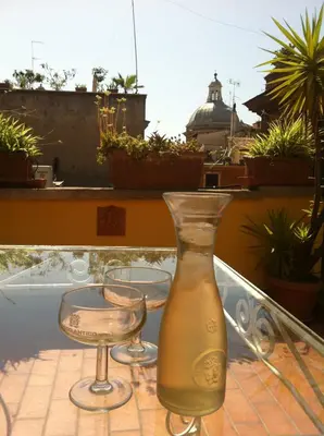 a vase sitting on top of a table with two glasses at Coliseum top floor with terrace and view in Rome