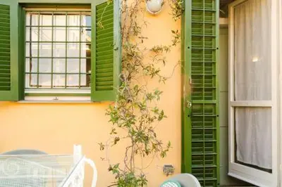 a building with green shutters and a table and a window at Coliseum top floor with terrace and view in Rome