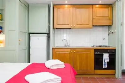 a kitchen with a red table with towels on it at Coliseum top floor with terrace and view in Rome