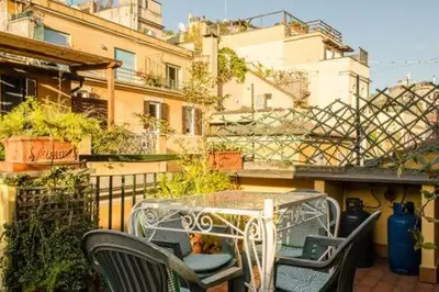 a patio with a table and chairs on a balcony at Coliseum top floor with terrace and view in Rome