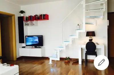 a living room with a staircase and a television at Aurelia House in Rome
