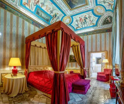 a bedroom with a red bed with a canopy at Residenza Ruspoli Bonaparte in Rome