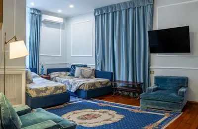 a living room with blue furniture and a tv at Residenza Ruspoli Bonaparte in Rome