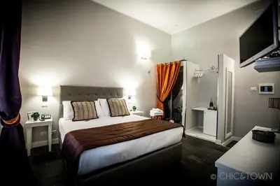 a hotel room with a bed and a television at Chic & Town Luxury Rooms Piazza di Spagna in Rome