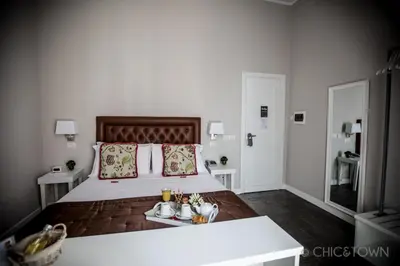 a bedroom with a large bed with two tables at Chic & Town Luxury Rooms Piazza di Spagna in Rome