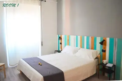 a bedroom with a white bed with a colorful headboard at Gianicolo Country Room in Rome