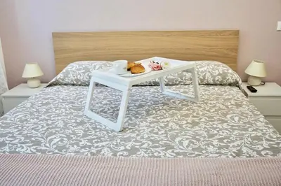 a bed with a tray with a teddy bear on it at Home Vatican Star in Rome