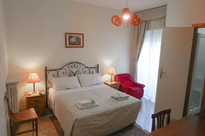 a bedroom with a bed and a red chair at The Condottieri in Rome
