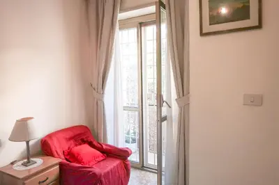 a red chair in a room with a window at The Condottieri in Rome