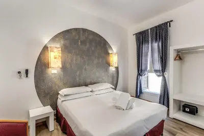a bedroom with a bed with a large wall at Hotel Santa Prassede in Rome