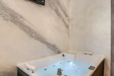 a bathroom with a bath tub with water on the wall at Hotel Santa Prassede in Rome