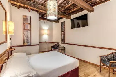 a bedroom with a bed and a tv on the wall at Hotel Santa Prassede in Rome