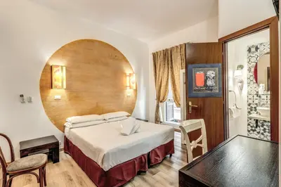 a hotel room with a large bed and a table at Hotel Santa Prassede in Rome