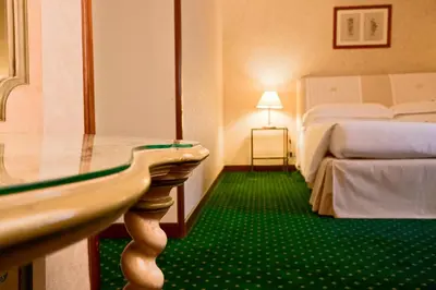 a bedroom with two beds with blue curtains and a window at Aldrovandi Residence City Suites in Rome