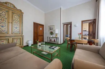 a living room with a table and a mirror at Aldrovandi Residence City Suites in Rome