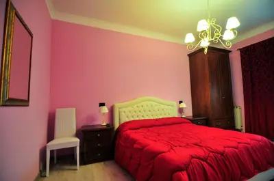 a bedroom with a red bed and pink walls at Casa Vacanza Katiuscia in Rome