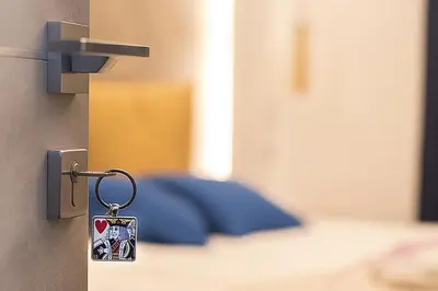 a key on a door with a bed in the background at My Love Suite in Rome