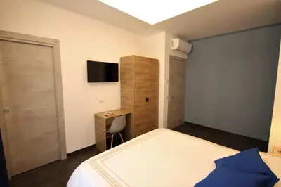 a bedroom with a bed and a desk and a television at My Love Suite in Rome