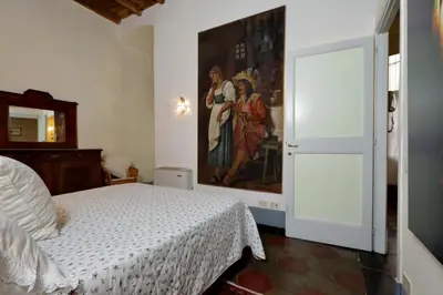 a bedroom with a bed and a painting on the wall at Monti Charm by the Colosseum in Rome