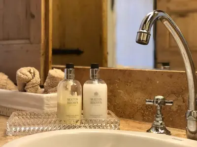 two bottles of soap sitting on a bathroom sink at Monti Charm by the Colosseum in Rome